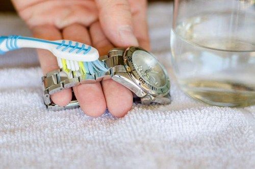 Làm sạch dây đeo đồng hồ kim loại bằng bàn chải đánh răng